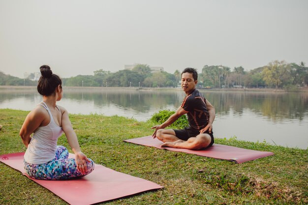 Coppia, yoga, lago e natura