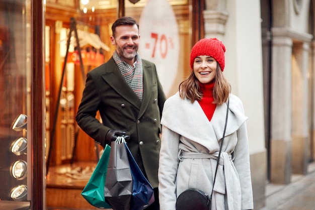 Coppie allegre durante lo shopping invernale