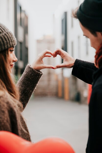 Coppie amorose che mostrano il gesto del cuore della mano