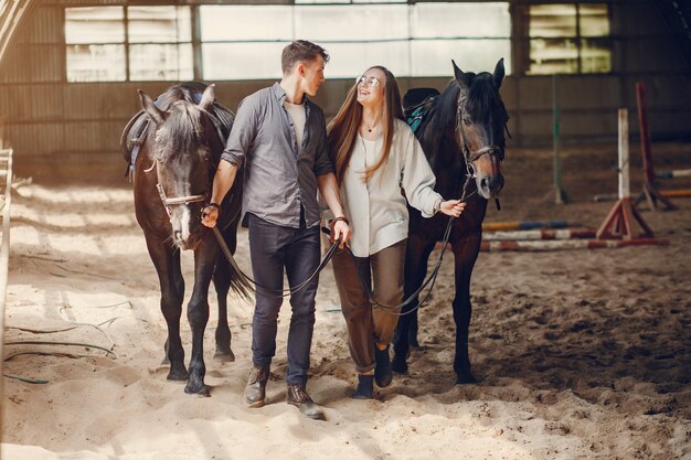 Coppie amorose sveglie con il cavallo sul ranch