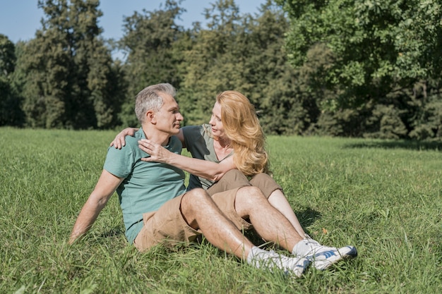 Coppie anziane che si siedono insieme sull'erba