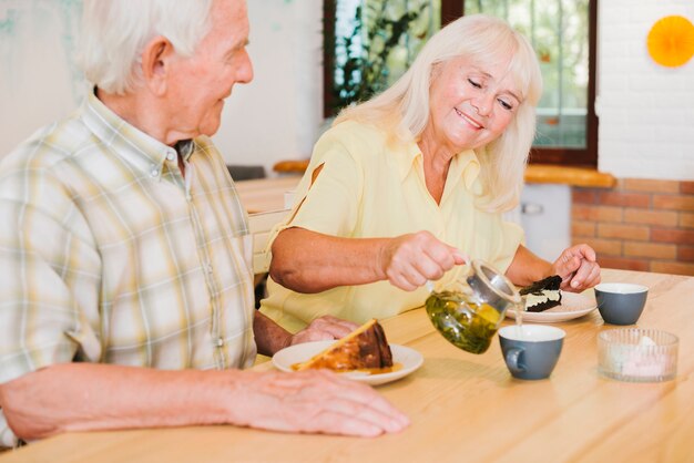 Coppie anziane romantiche che mangiano tè in caffè