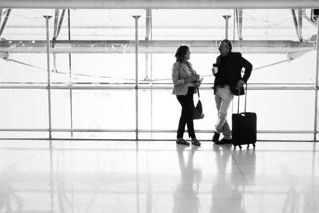 Coppie caucasiche che parlano insieme all&#39;aeroporto