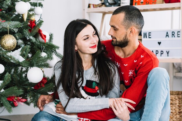 Coppie che abbracciano vicino all&#39;albero di abete