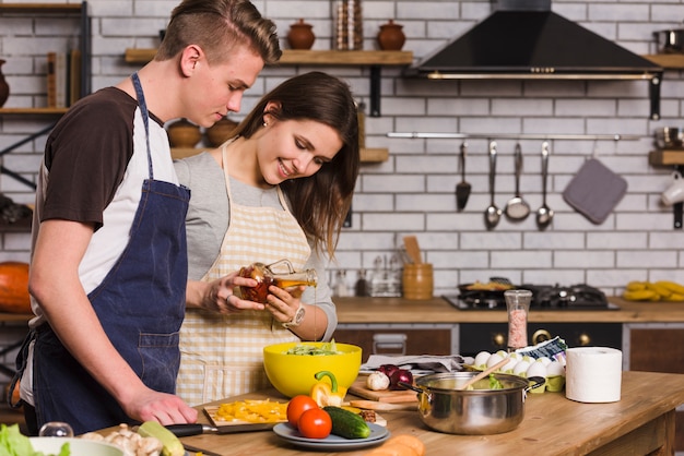 Coppie che cucinano insalata vegetariana con verdure fresche