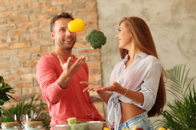 Coppie che cucinano le verdure in cucina