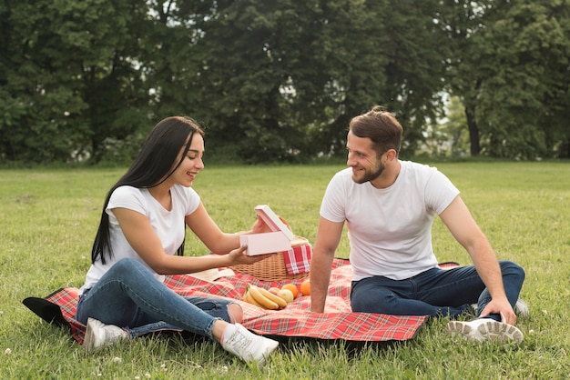 Coppie che posano su una coperta da picnic