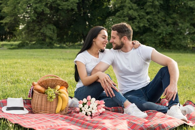 Coppie che posano su una coperta da picnic