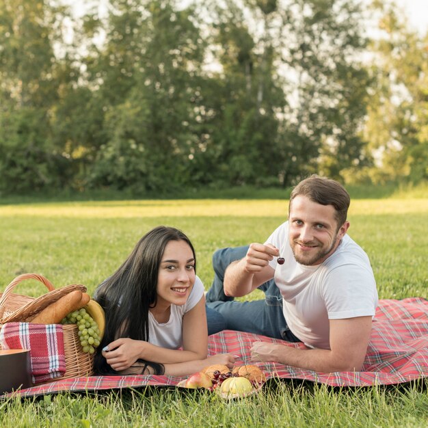 Coppie che posano su una coperta da picnic