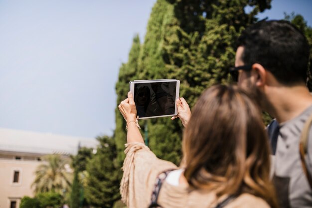 Coppie che prendono selfie sulla tavoletta digitale