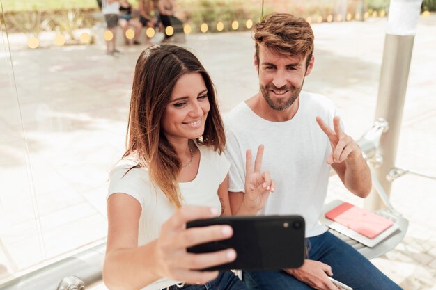 Coppie che prendono un selfie e che mostrano il segno di pace