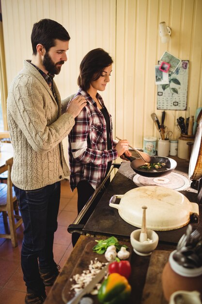 Coppie che preparano insieme cibo in cucina