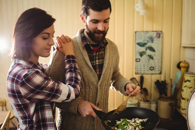 Coppie che preparano insieme cibo in cucina