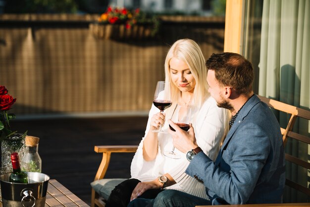 Coppie che si siedono nel patio che gode bevendo vino