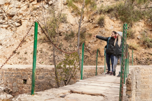 Coppie con lo zaino che camminano sul ponte