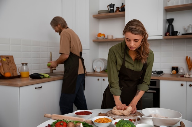 Coppie del colpo medio che cucinano insieme