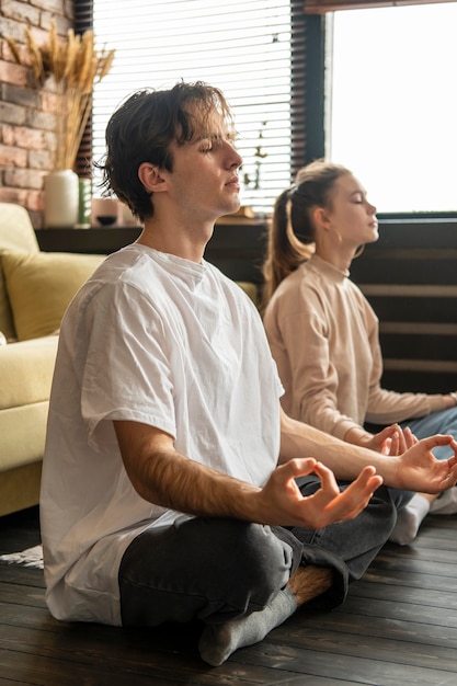 Coppie del colpo pieno che meditano insieme