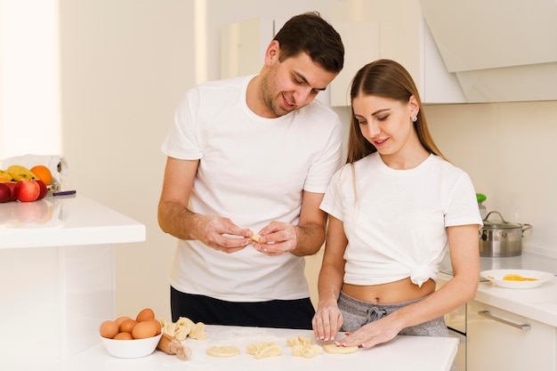 Coppie dell'angolo alto che preparano pasta