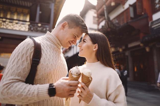 Coppie della persona appena sposata che mangiano il gelato da un cono su una via a Shanghai vicino a Yuyuan Cina.