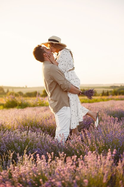 Coppie della Provenza che si rilassano nel campo di lavanda. Signora in abito bianco.