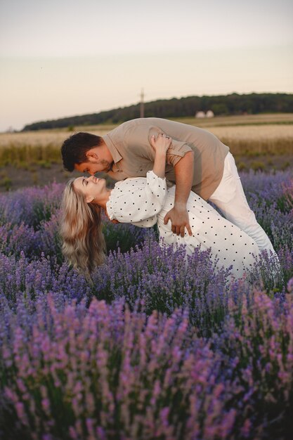 Coppie della Provenza che si rilassano nel campo di lavanda. Signora in abito bianco.