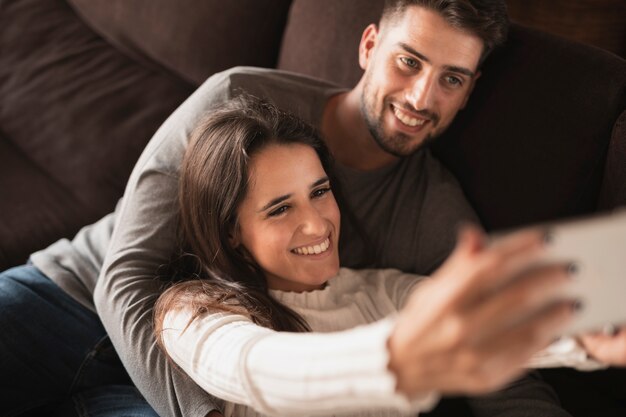 Coppie di smiley a casa che prendono selfie