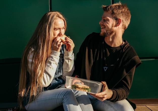 Coppie di smiley che mangiano insieme all'aperto