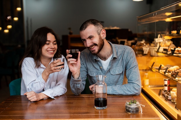 Coppie di smiley che tengono i bicchieri di caffè