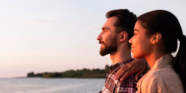 Coppie di vista laterale che godono del tramonto con lo spazio della copia