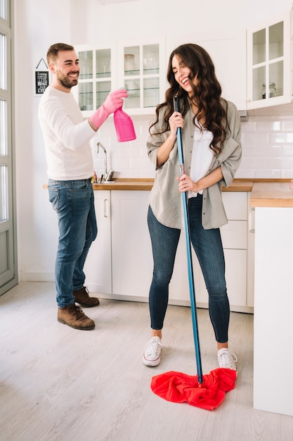 Coppie divertendosi mentre pulendo cucina