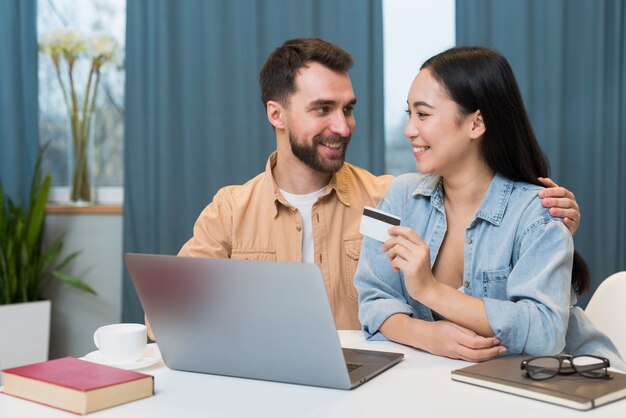 Coppie felici che comperano online mentre allo scrittorio