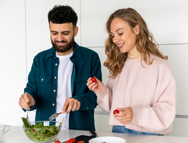 Coppie felici che cucinano insieme a casa