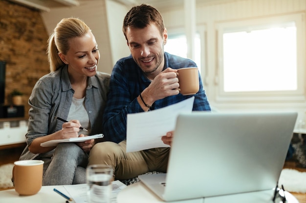 Coppie felici che fanno il loro bilancio domestico mentre passano insieme le finanze