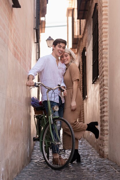 Coppie felici che posano con la bicicletta fuori