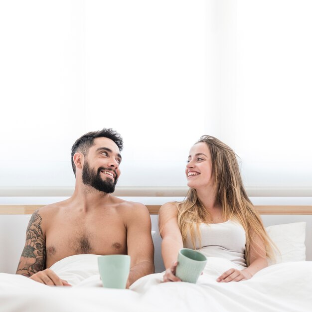 Coppie felici con la tazza di caffè che se lo esaminano