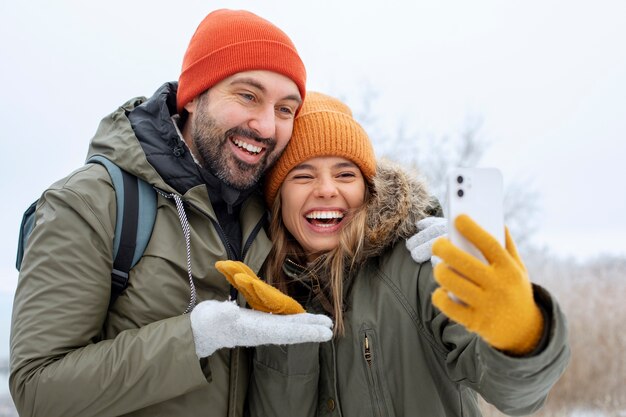 Coppie felici del colpo medio che prendono selfie