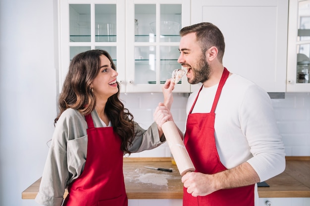 Coppie felici in grembiuli sulla cucina