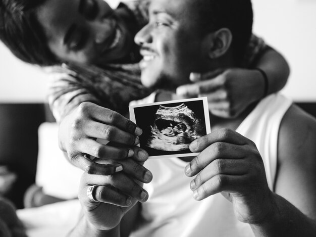 Coppie nere che mostrano foto di ricerca di ultrasuono del bambino