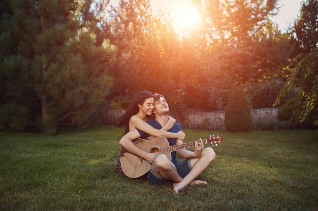 Coppie romantiche che si siedono sull'erba nel giardino