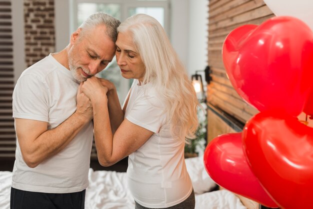 Coppie senior che celebrano il giorno di biglietti di S. Valentino a casa