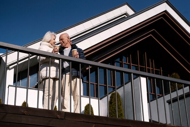 Coppie senior di angolo basso con le tazze di caffè