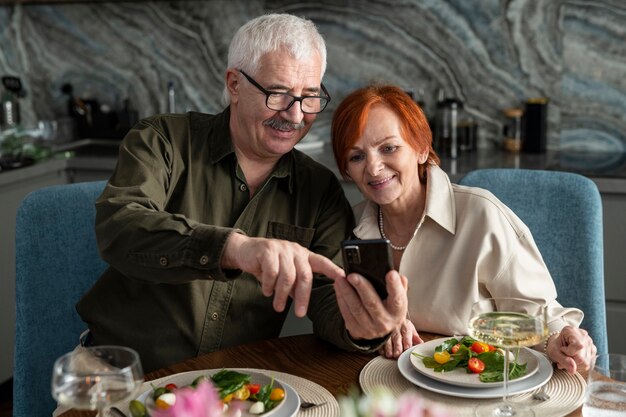 Coppie senior di smiley del colpo medio che prendono selfie