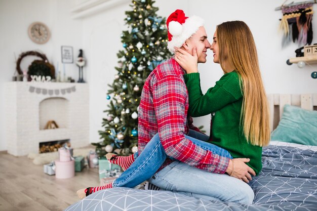 Coppie sorridenti sul letto a natale