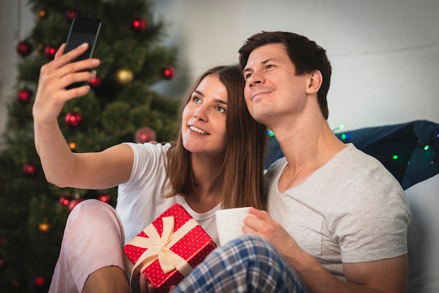 Coppie sveglie che prendono un selfie a letto