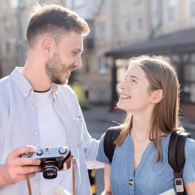 Coppie turistiche sveglie all'aperto con la macchina fotografica