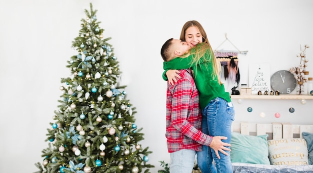 Coppie vicino all&#39;albero di Natale in camera da letto