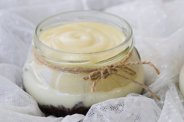 Corda legata intorno al barattolo di cagliata di limone sopra il tessuto di pizzo bianco