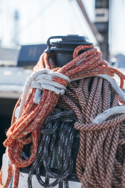 Corde nautiche, buntine, verricello e cablet impilati sul ponte di uno yacht da regata professionale o di una barca a vela, attaccati all'albero o allo strallo, diversi colori