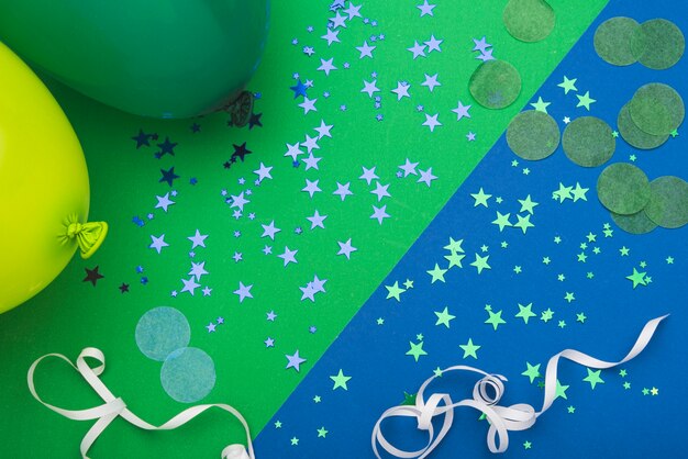 Coriandoli stelle e palloncini su sfondo colorato