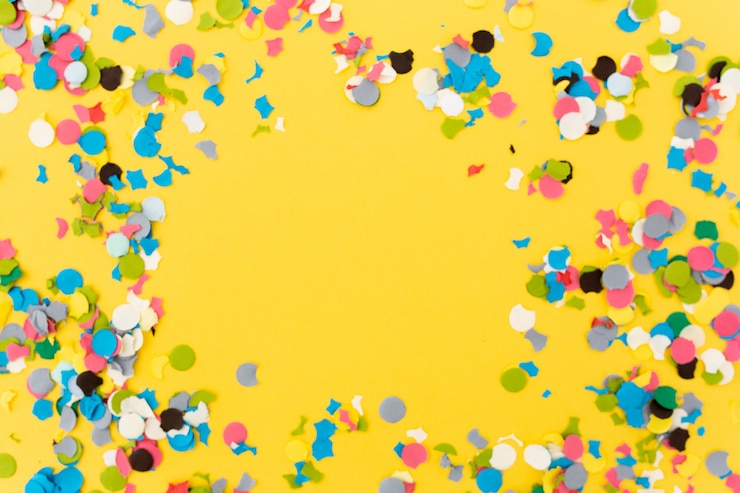 Foto gratuito coriandoli su sfondo giallo dopo aver terminato la festa